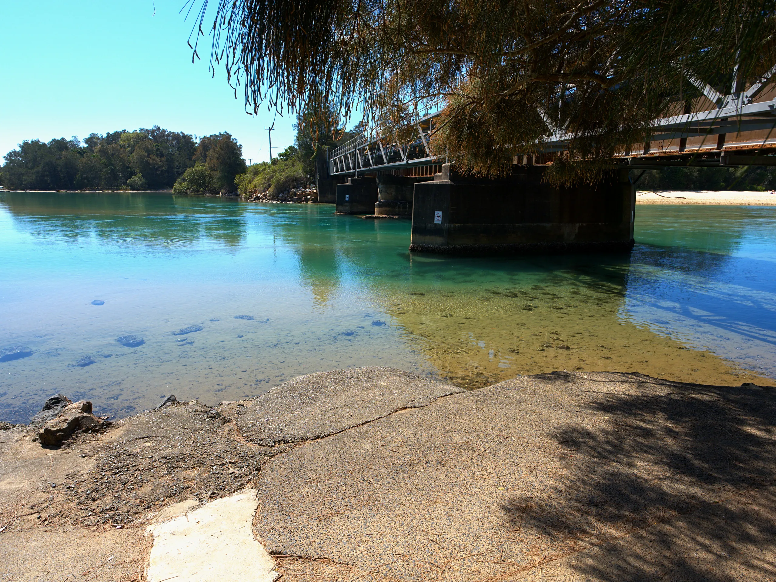 Clear shallow water over sand beneath the railway bridge at Boambee Creek, Sawtell